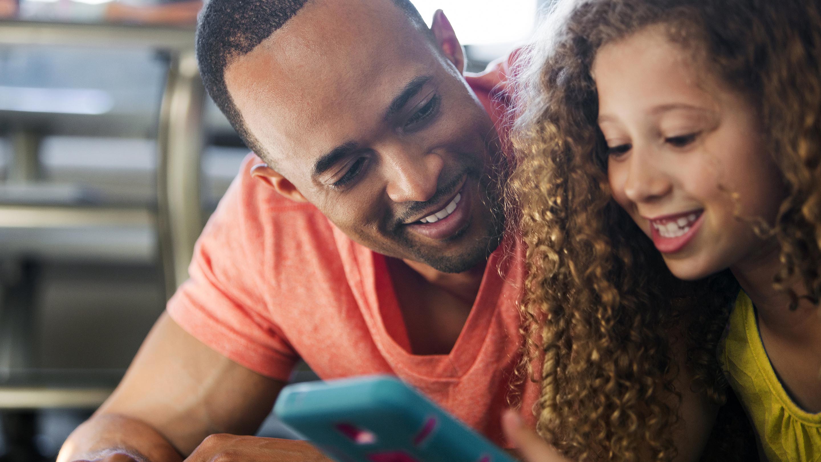 Father and daughter looking at app on mobile